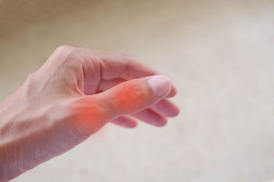 Hand with thumb glowing red to indicate pain